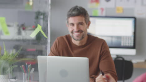 Mujer-De-Negocios-En-Oficina-Creativa-Escribiendo-Ideas-En-Pantalla-Transparente-Hablando-Con-Un-Colega-Masculino