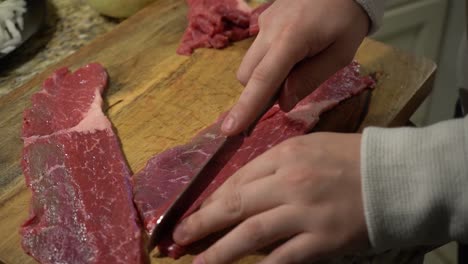 slicing steak on a cutting board in slow motion.
