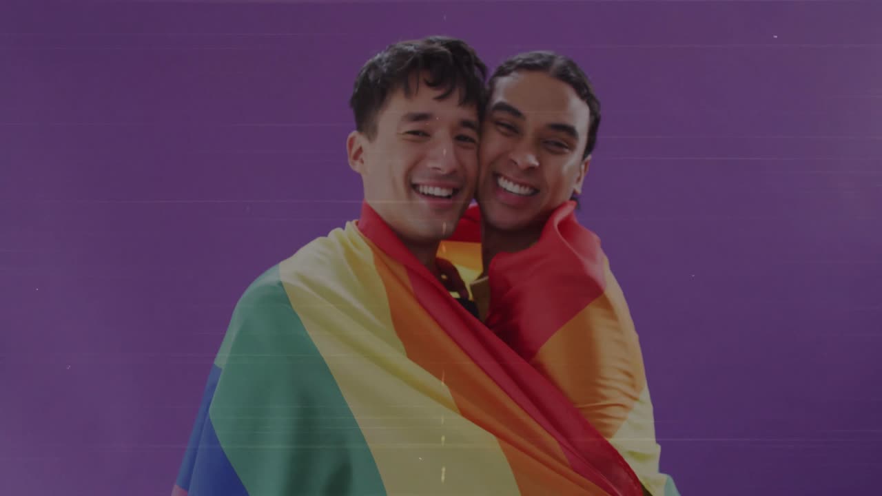 恋人同士のカップルがプライドフラッグを持ち、その後肩にかけ、LGBTQ+の支援を表明している。