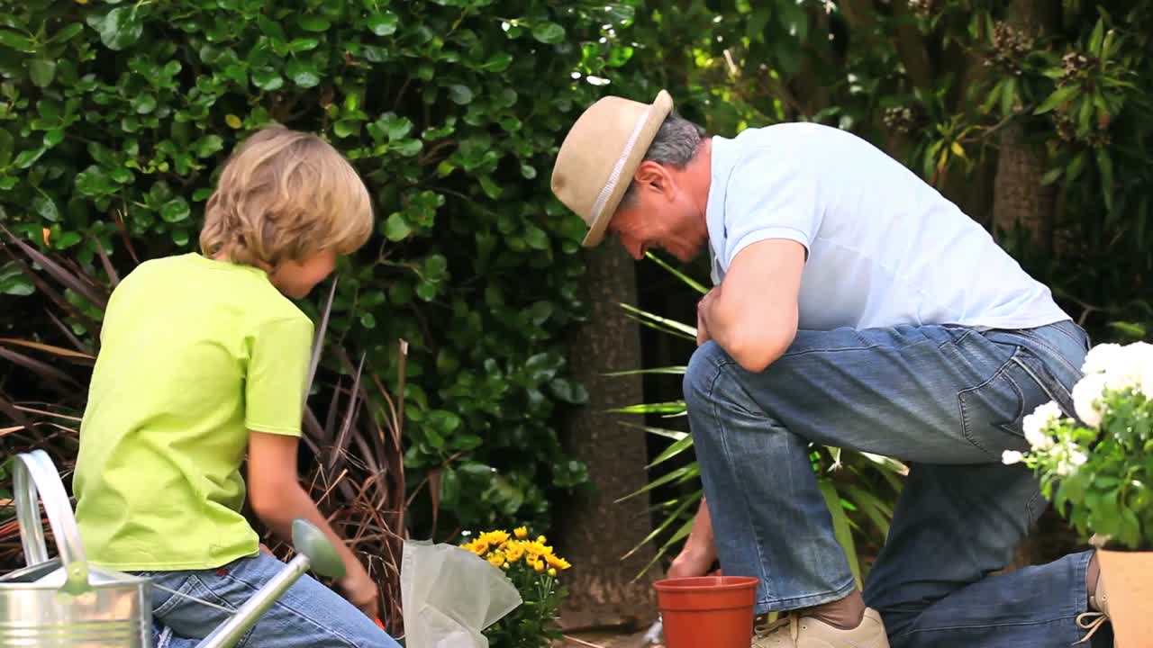 abuelo y nieto orgullosos de hacer algo de jardinería