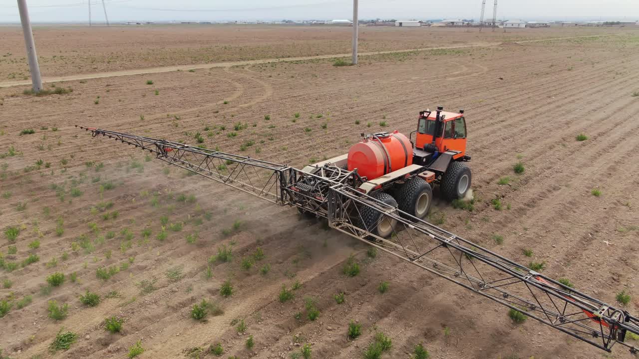 pulverizador de tractor agrícola trabajando en tierras de cultivo en ucrania, ciudad de kyiv durante el día, tiro de seguimiento aéreo