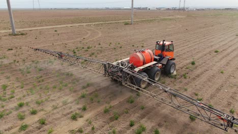 Agricultural-Tractor-Sprayer-Working-On-Farmland-In-Ukraine,-Kyiv-City-During-Daylight,-Aerial-Tracking-Shot