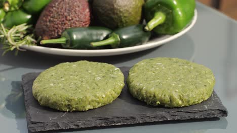 raw green patties ready for cooking with fresh vegetables