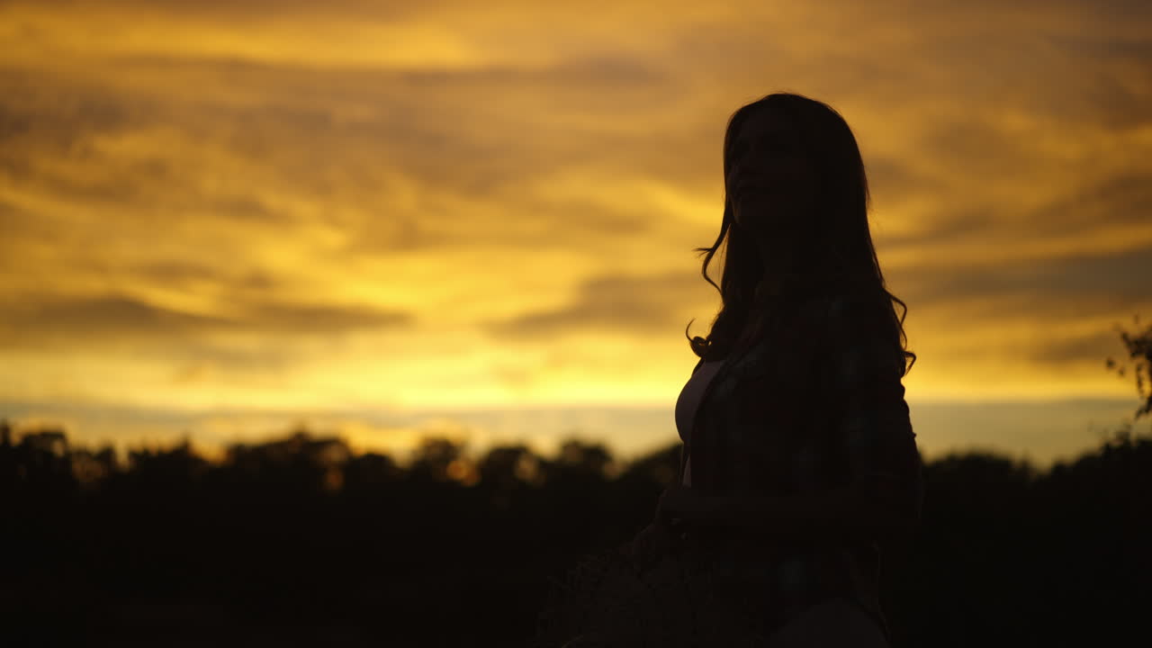 Silhouette of a woman during sunset | Premium Stock Video Footage