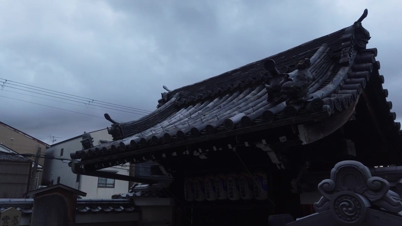 Primo piano con panoramica lenta dell'architettura tradizionale del tetto di un tempio e dettagli ornamentali a Kyoto, Giappone
