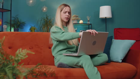 caucasian young woman use laptop surprised by bad news, fortune loss, fail, lottery results at home