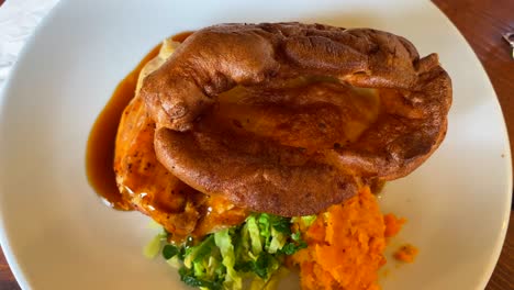 traditional british sunday roast, chicken with yorkshire pudding, gravy and vegetables, classic english food, lunch dish in england, top view, 4k shot