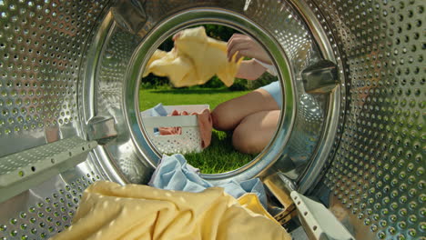 person loading laundry in washing machine outdoors