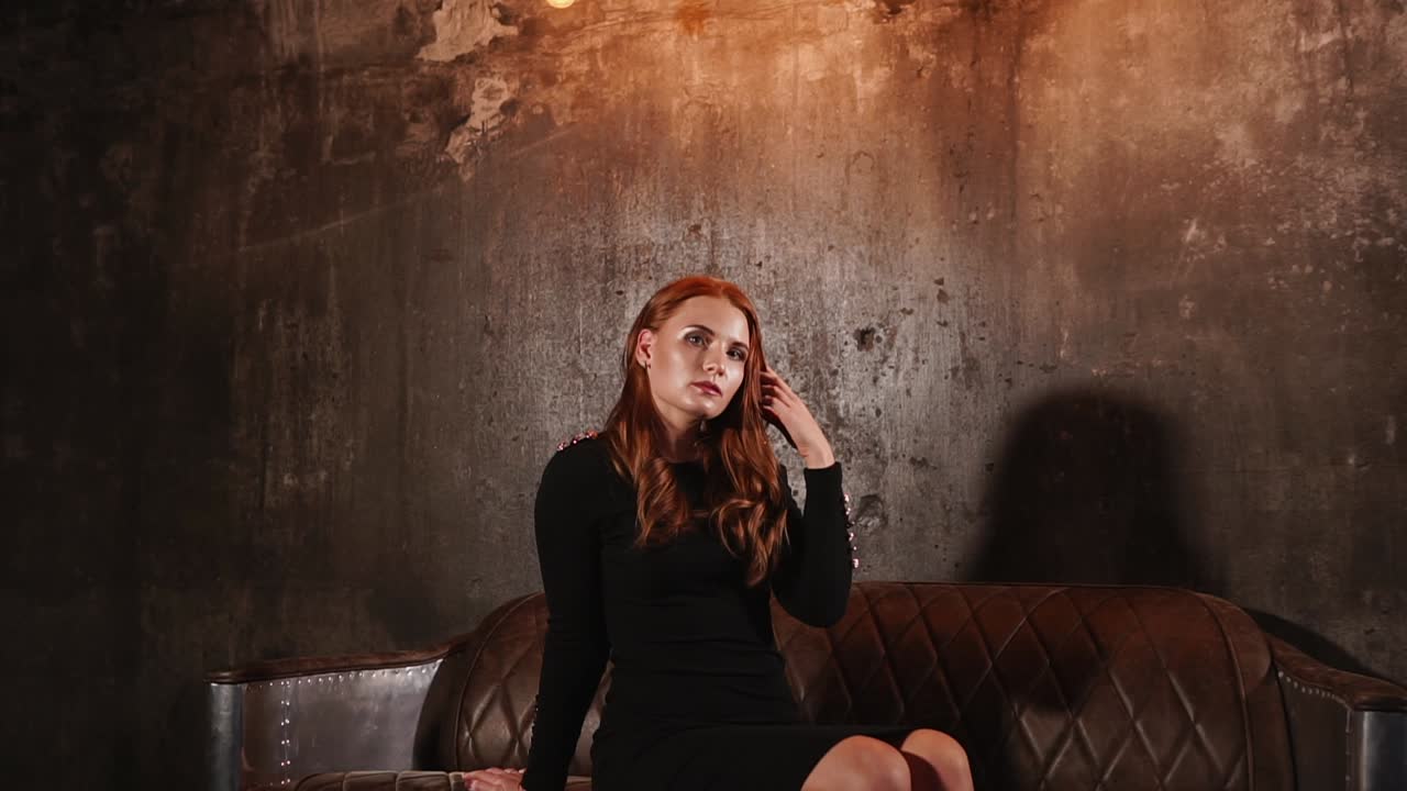 빈티지 소파에 검은 드레스를 입은 여자