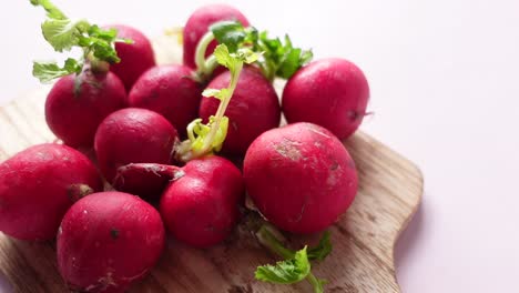 fresh red radishes on a wooden cutting board