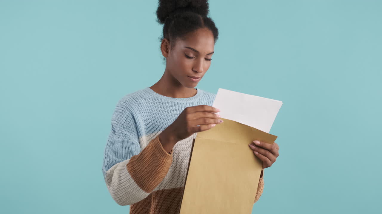 행복한 여자가 봉투를 열고 미소 짓고