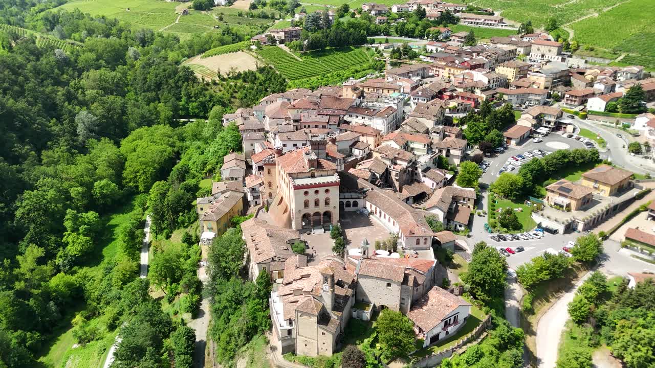 Barolo Castle in Langhe Wine Region, Cuneo, Piedmont, Italy. 4K Aerial view of the village and the vineyards, tilt up flying forward.