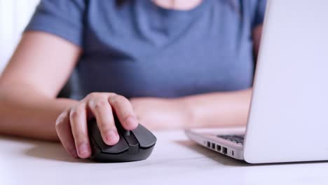 women are using mouse wireless with a laptop on a desk in the room