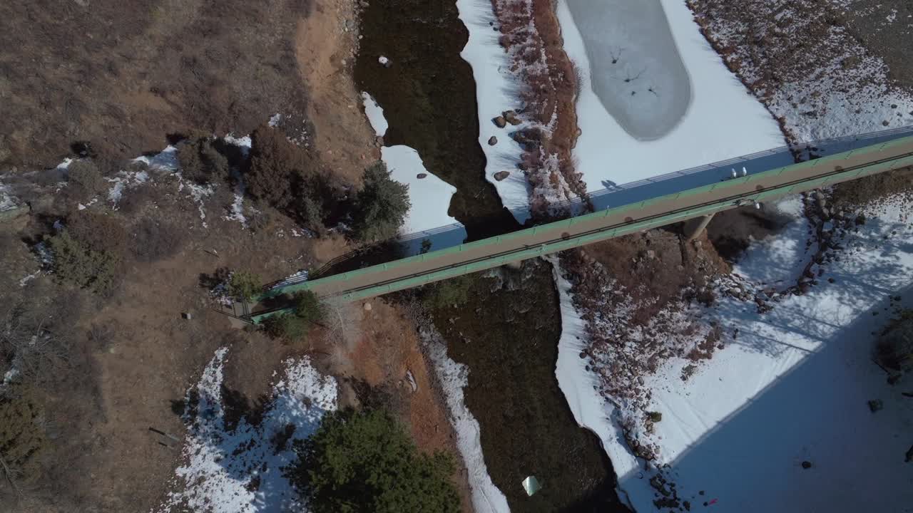 Clear Creek frozen river Winter Central City Parkway Idaho Springs Blackhawk Colorado aerial drone highway road bridge snow birdseed sunny forest Clear Creek Gilpin County circle pan down motion
