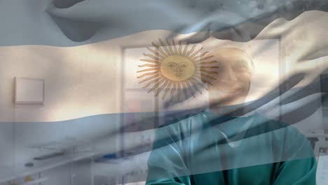 animation of flag of argentina over biracial surgeon standing arms crossed in operation theater