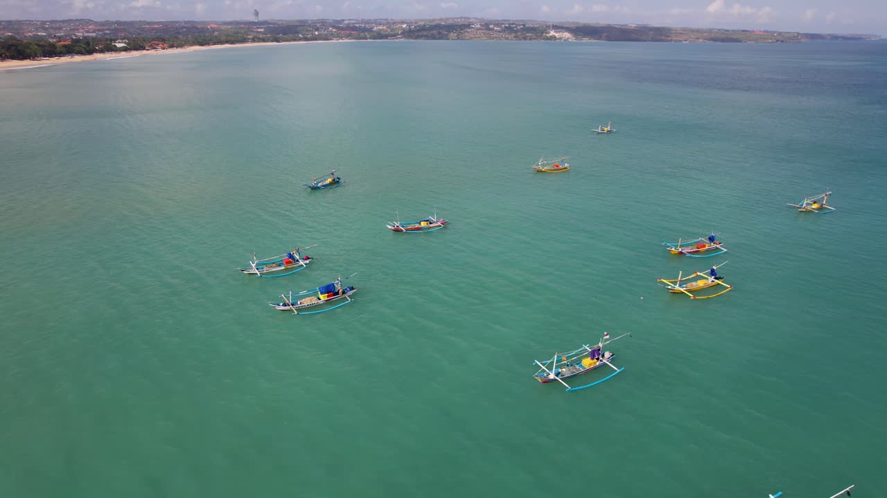 열대 섬 발리 근처의 푸른색 투명한 파도에서 흔들리는 인도네시아의 전통적인 주킹 보트