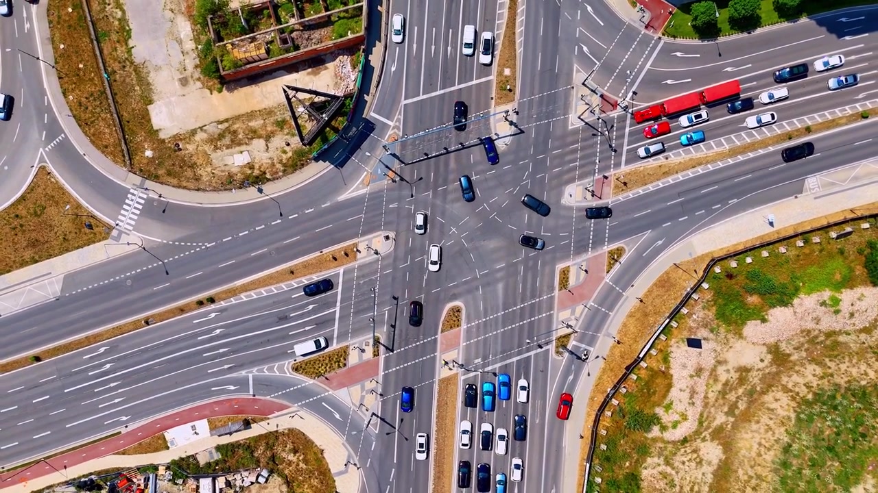 Sunny day view of a large urban crossroads, Bratislava, Slovakia. Elevated drone footage showing traffic movement across multiple lanes of asphalt.