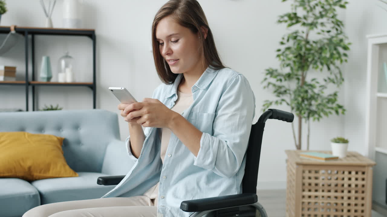 joven en silla de ruedas usando un teléfono inteligente