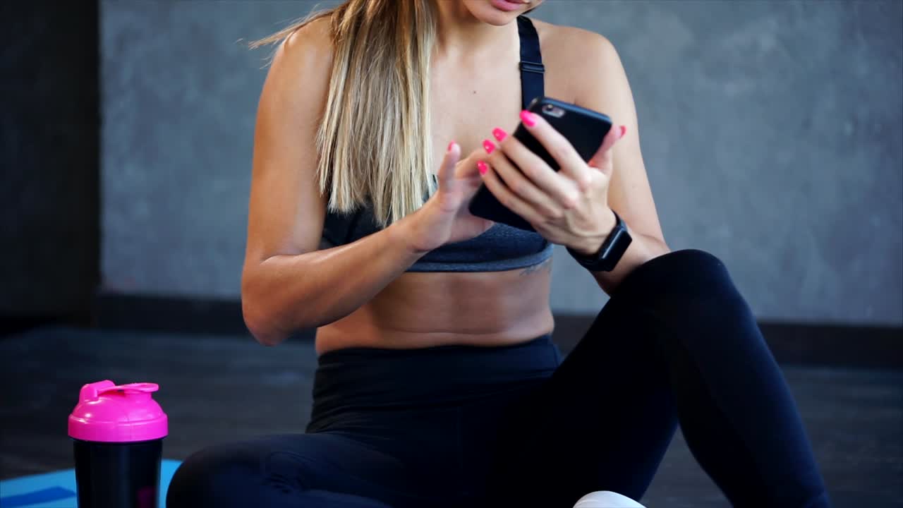 Woman using a smartphone while resting after a workout