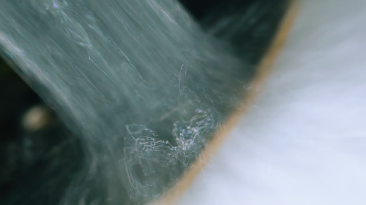 heavy water runs down from faucet in modern metal sink