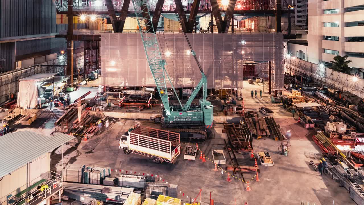 Time-lapse of crane and construction worker in under construction building site at night. Construction industry, industrial business, or civil engineering technology concept. Zoom out