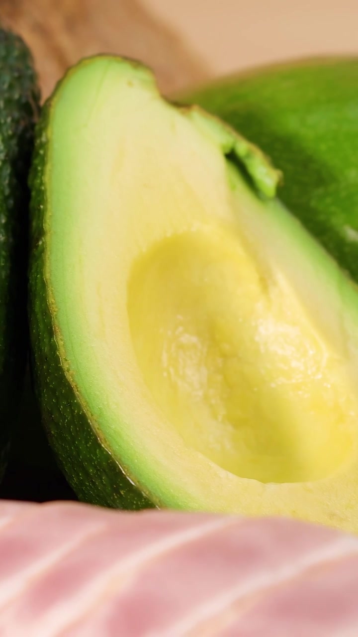 Una vivace esposizione di vari grassi sani, inclusi avocado, noci e oli, che ne evidenzia le texture e i colori.
