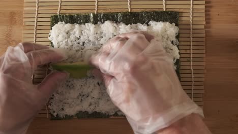 un chef preparando rollos de sushi en la cocina