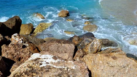 Static-shot-of-sea-waves-crashing-on-the-rocks-of-the-Italian-Riviera-in-the-town-of-Varigotti-in-the-north-of-Italy