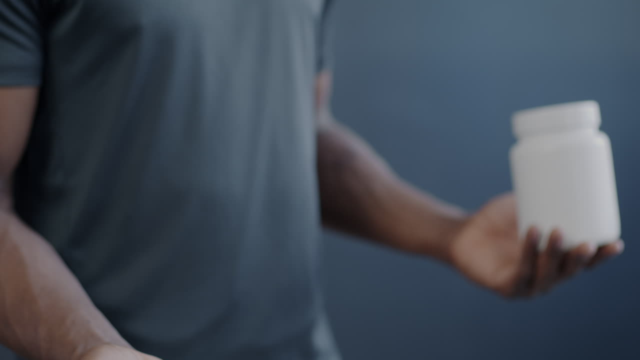 Man holding pills and supplement container