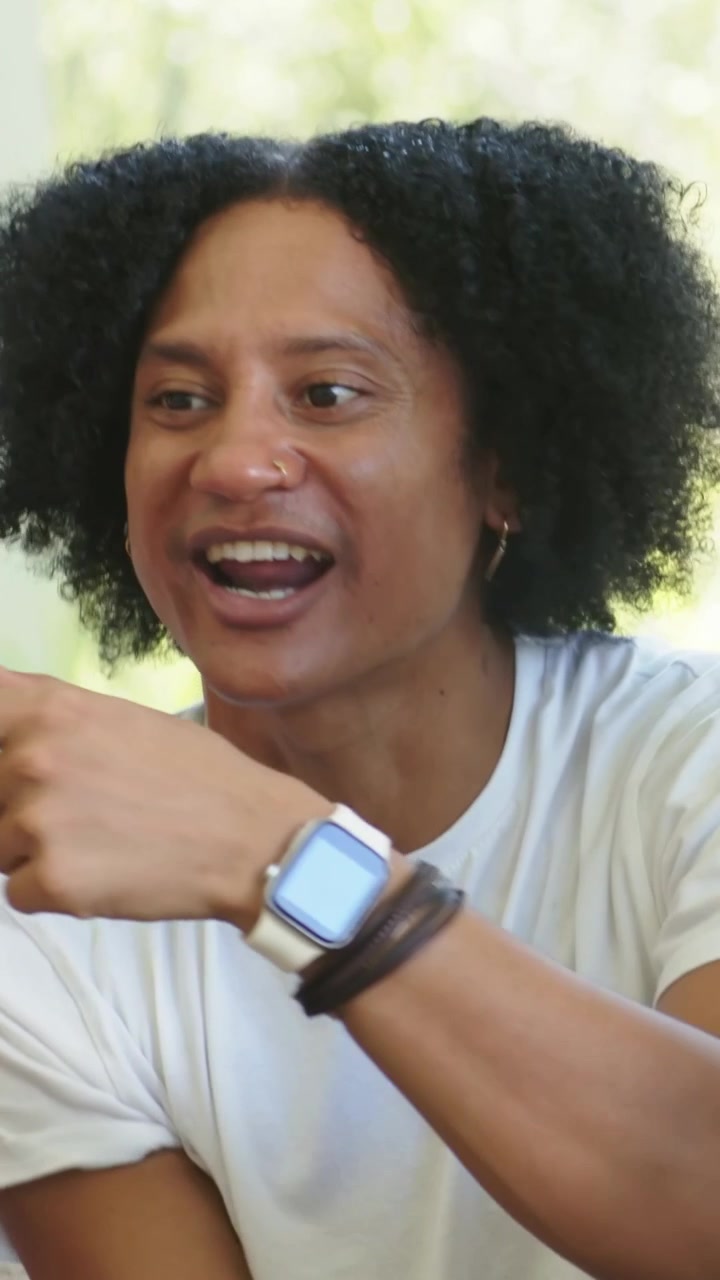 Uomo seduto che reagisce mentre un uomo in piedi alza le braccia, smartwatch animato con indicatore di pulsazioni che mostra statistiche di marketing