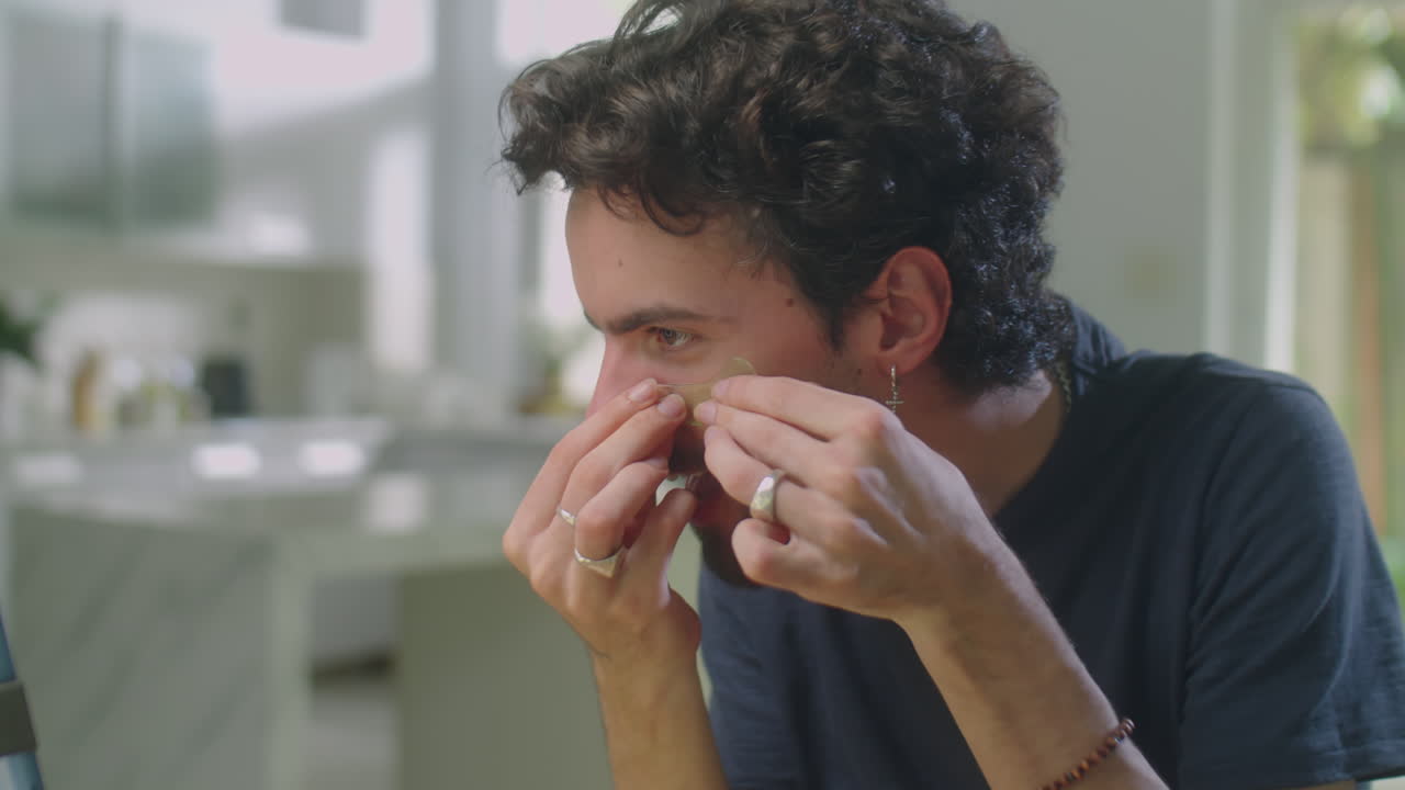 Male Beauty Blogger Applying Eye Patches