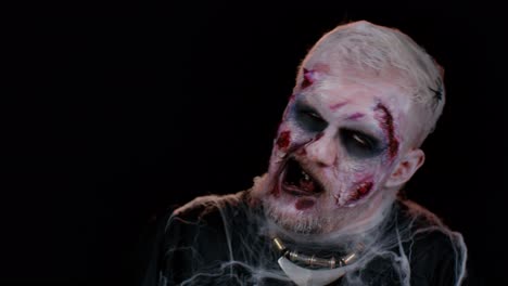 Unheimlicher-Mann-Mit-Schrecklich-Gruseligem-Halloween-Zombie-Make-up,-Der-Unter-Krämpfen-Gesichter-Macht-Und-Versucht,-Angst-Zu-Machen