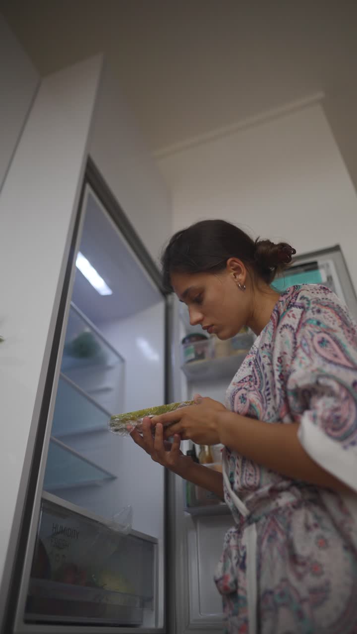Woman checking refrigerator for papaya