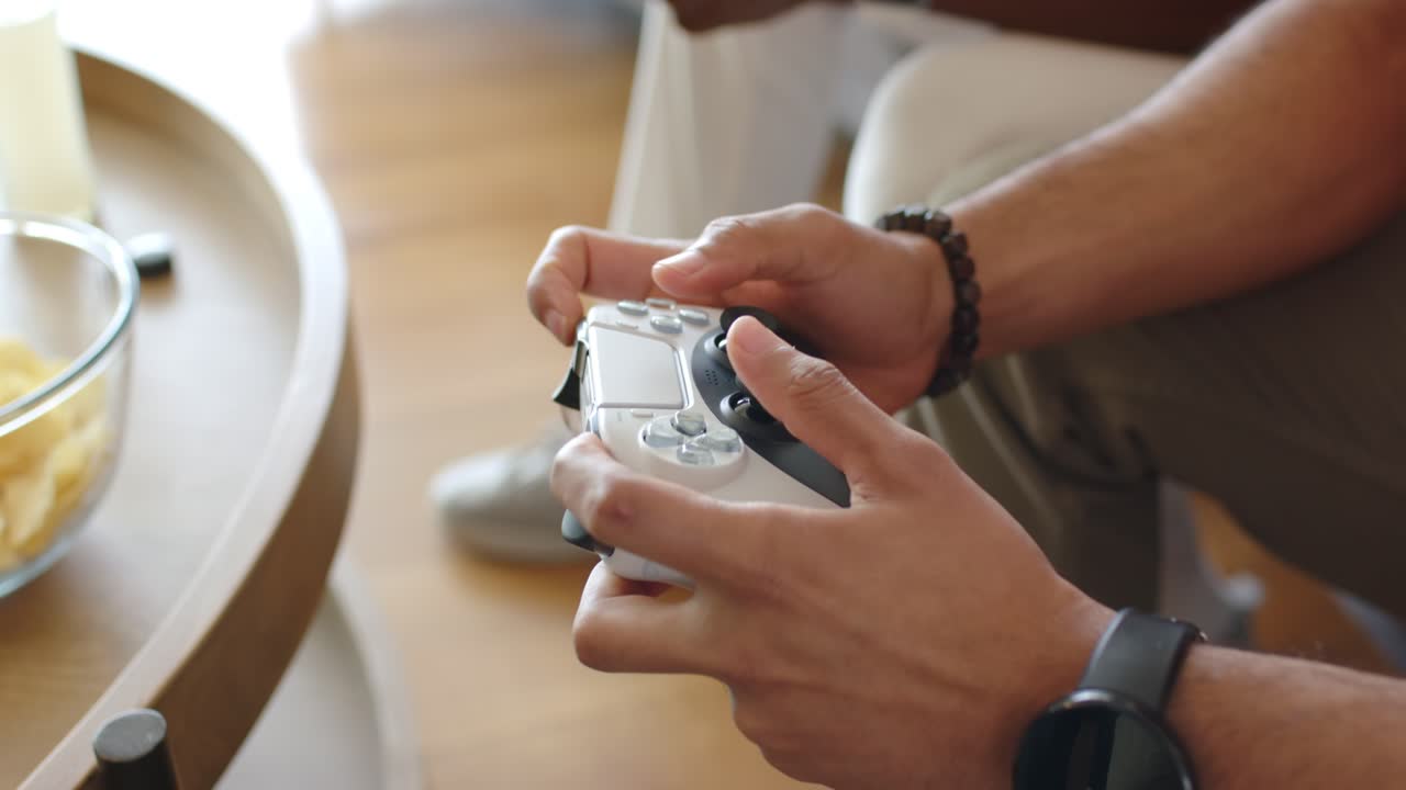 Hands raising controller on sofa at startup, tilting joysticks and pressing triggers for gameplay
