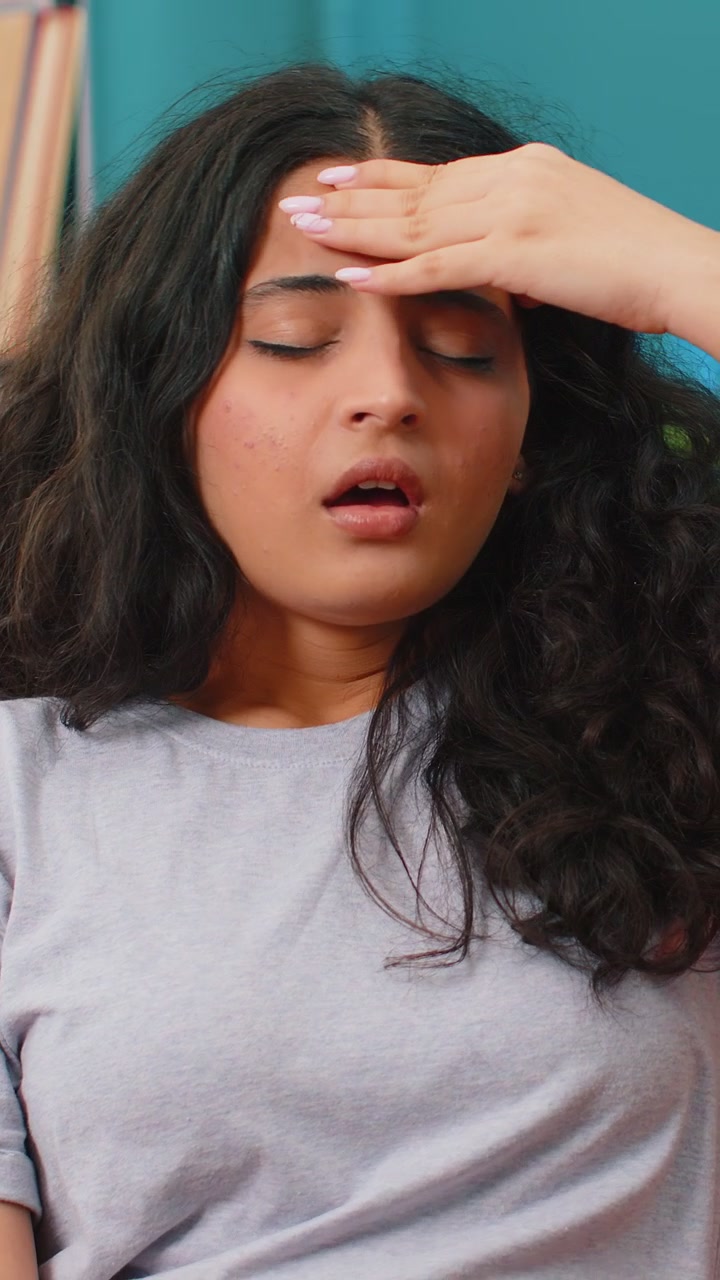 Sick ill indian woman rubbing temples to cure headache problem suffering from migraine stress