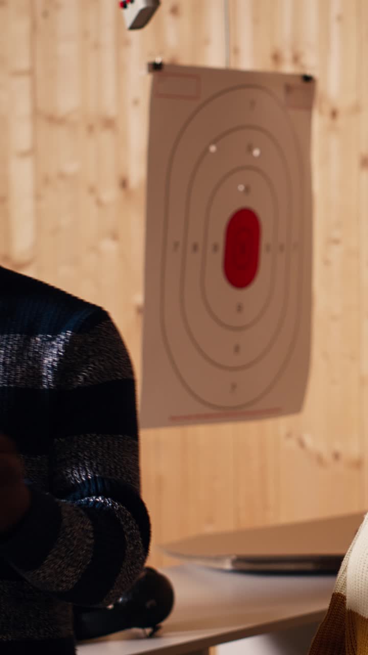 Vertical video Shooting gallery expert demonstrating how to safely reload pistol and cock gun