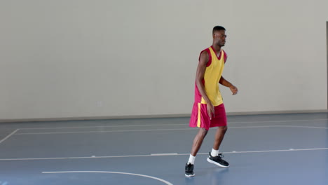 african american man plays basketball indoors, with copy space