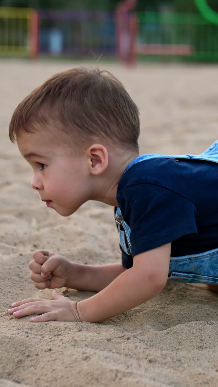 Water playing with splashing. Little funny boy playing on a river beach. Vertical video