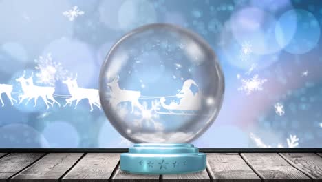 Animation-of-christmas-snow-globe-with-santa-claus-in-sleigh-and-snow-falling-on-blue-background