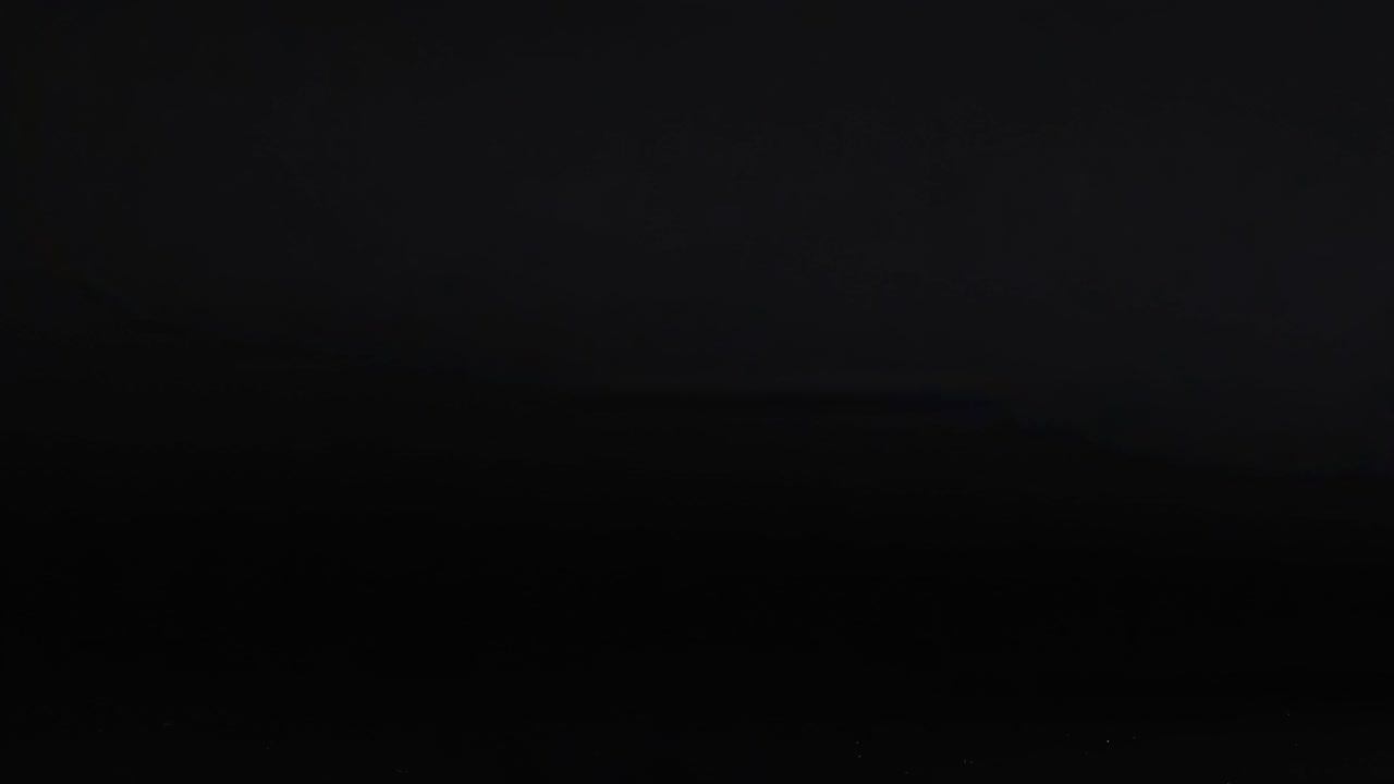 Green and orange tennis balls captured in motion on a dark backdrop, showcasing dynamic movement and vivid contrast.