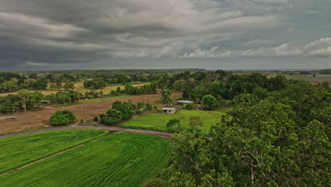 guarumal panama aerial v3 low level drone flyover cultivated farmland towards the skyline with car driving on the country road with dark stormy clouds in the sky - shot with mavic 3 cine - april 2022