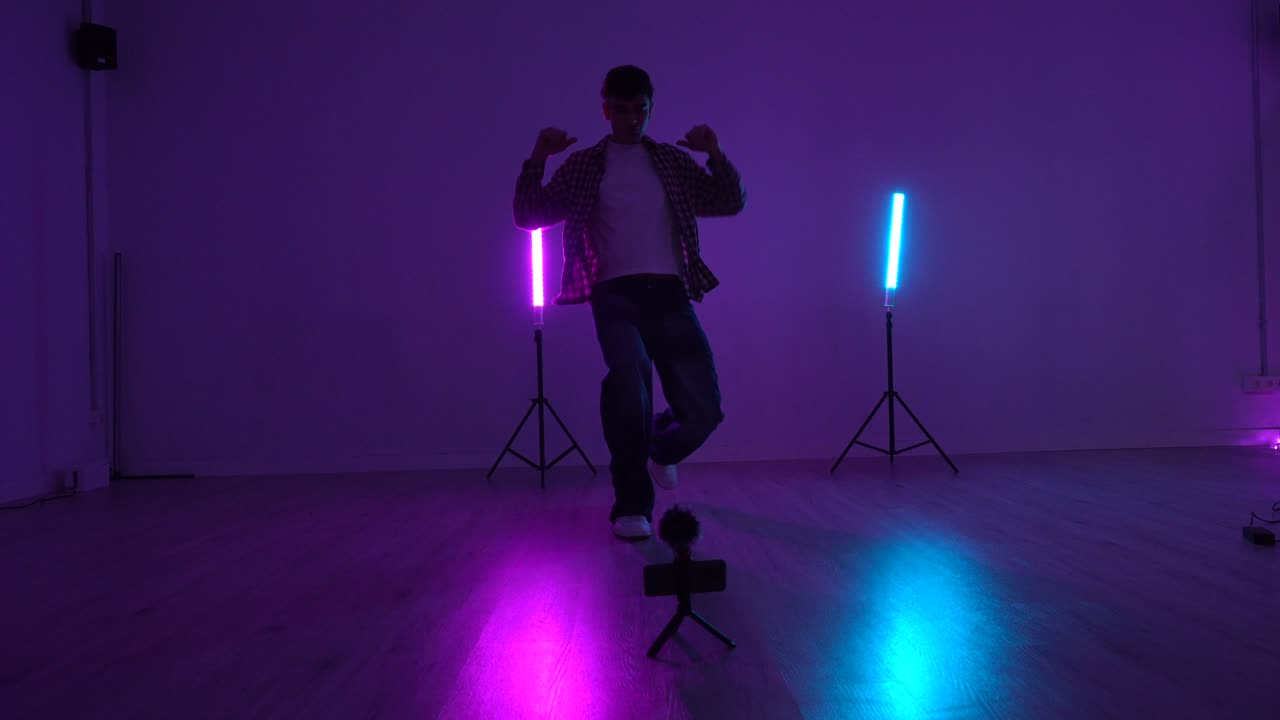 Uomo che balla in uno studio con luci al neon