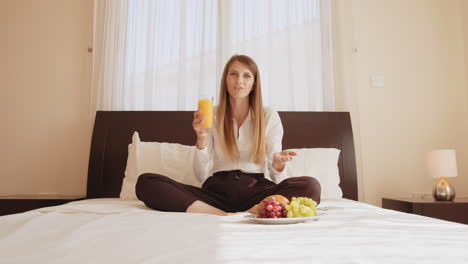 mujer disfrutando del desayuno en la cama