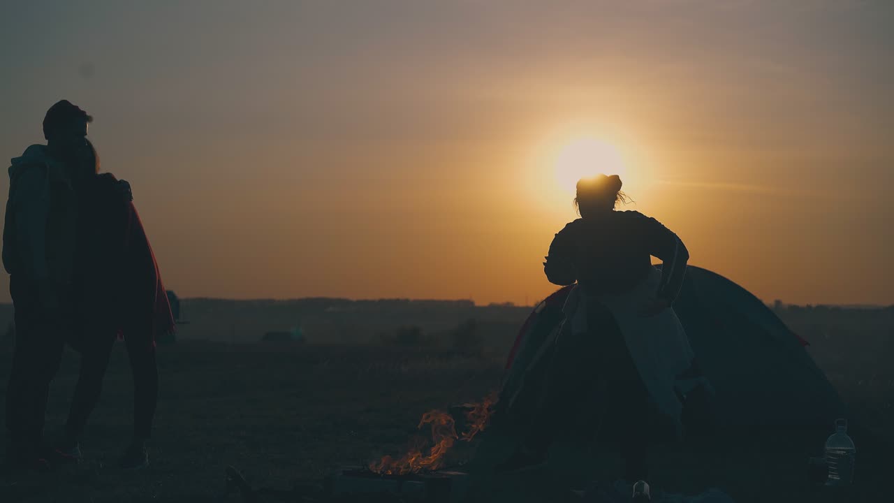 ⁇ 한 소녀가 불꽃과 친구들과 가을 저녁에 춤을 춘다.