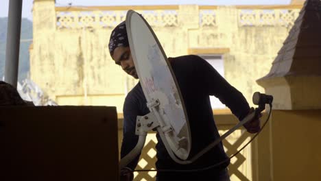 indian-boy-with-hairs-band-bandana-fixing-dish-antina-tv-airtell-checking-signal