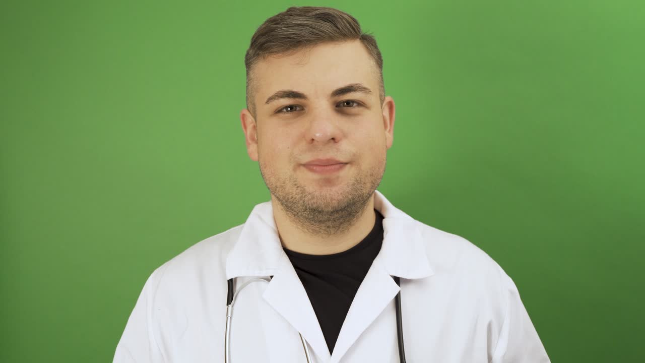Homem caucasiano posando como médico, tirando a máscara protetora e sorrindo. Conceito de fim de pandemia ou quarentena. Filmagem em tela verde.