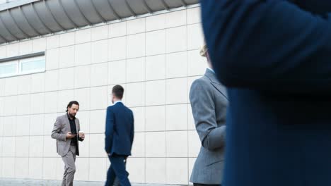 caucasian young businesswoman walking down street and using smartphone