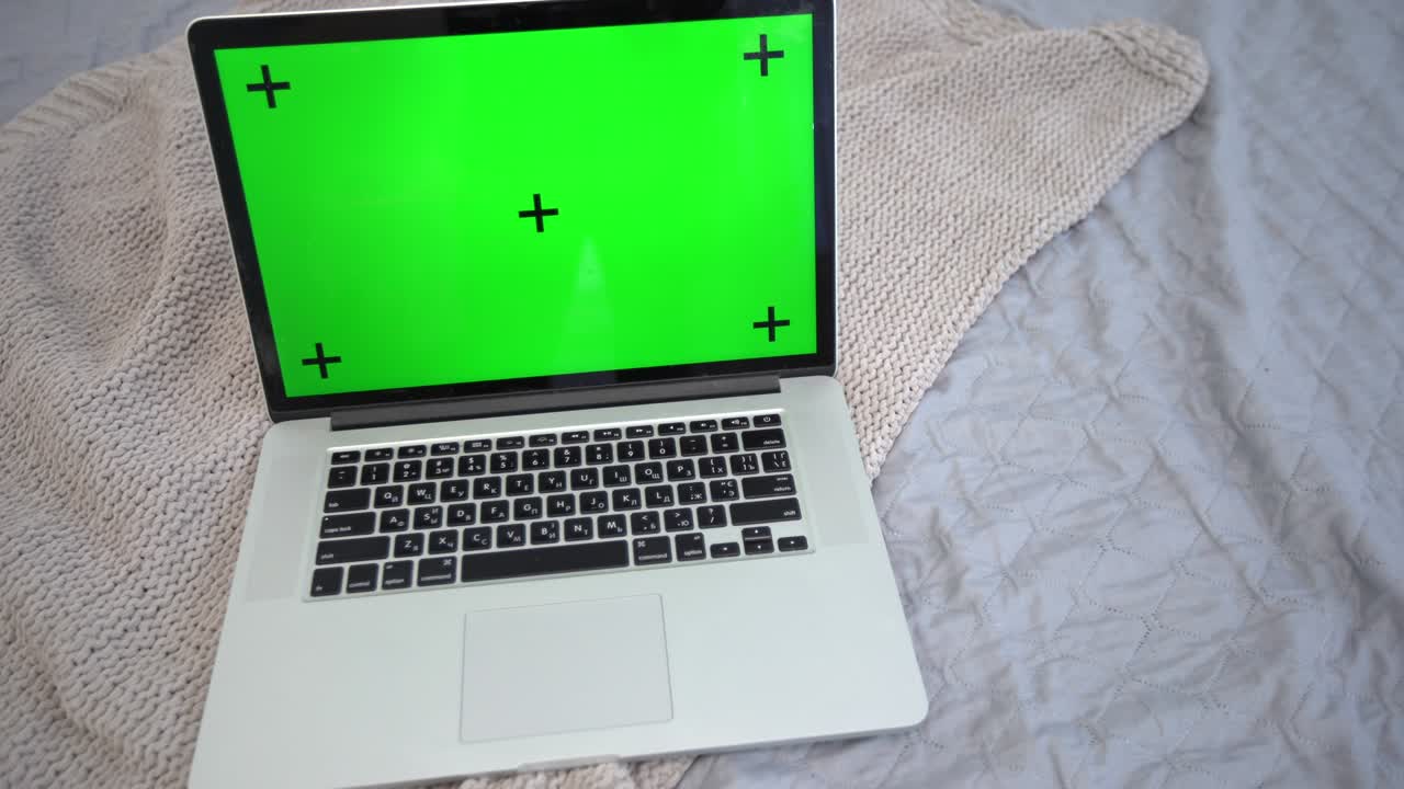 computadora portátil con pantalla verde en una cama. concepto para chats de video de aprendizaje a distancia virtual remoto.