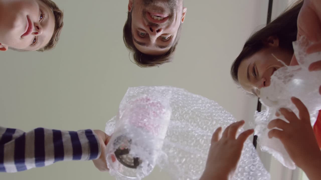 새로운 집 에서 카드보드 상자 를 열고 있는 가족 4k