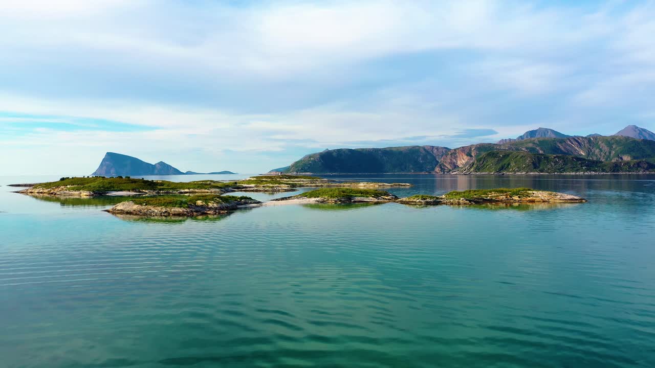 Aerial view towards small islands, white sand and turquoise sea, on the coast of the Sommaroy island, at the Arctic ocean, sunny, summer day, in Troms, Norway - low, dolly, drone shot